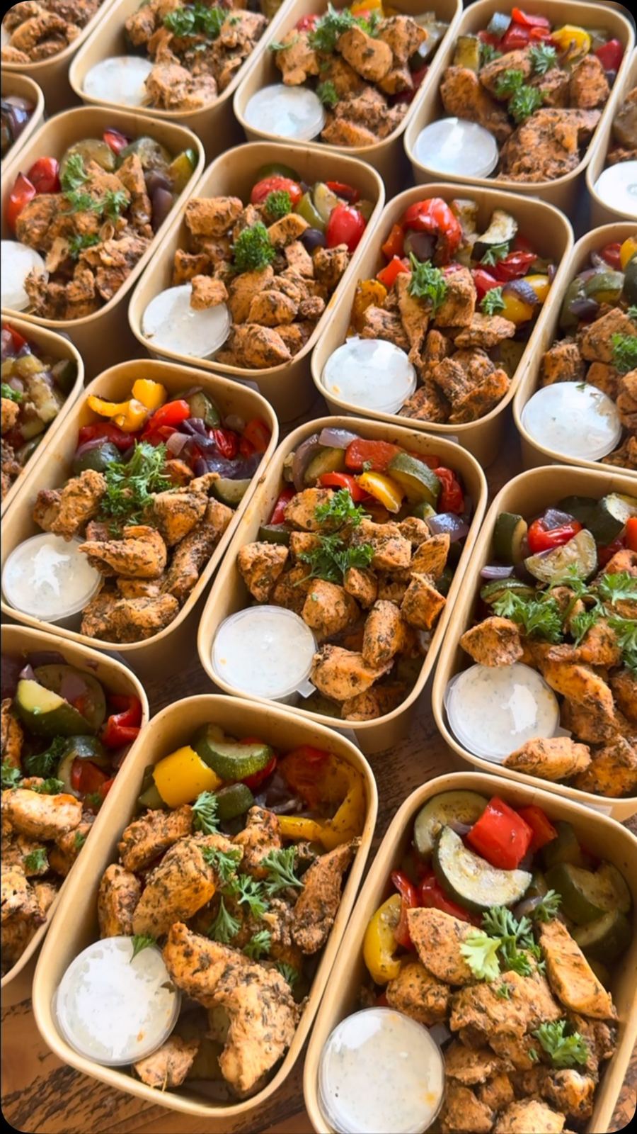 Trays of herby chicken bowls being packed
